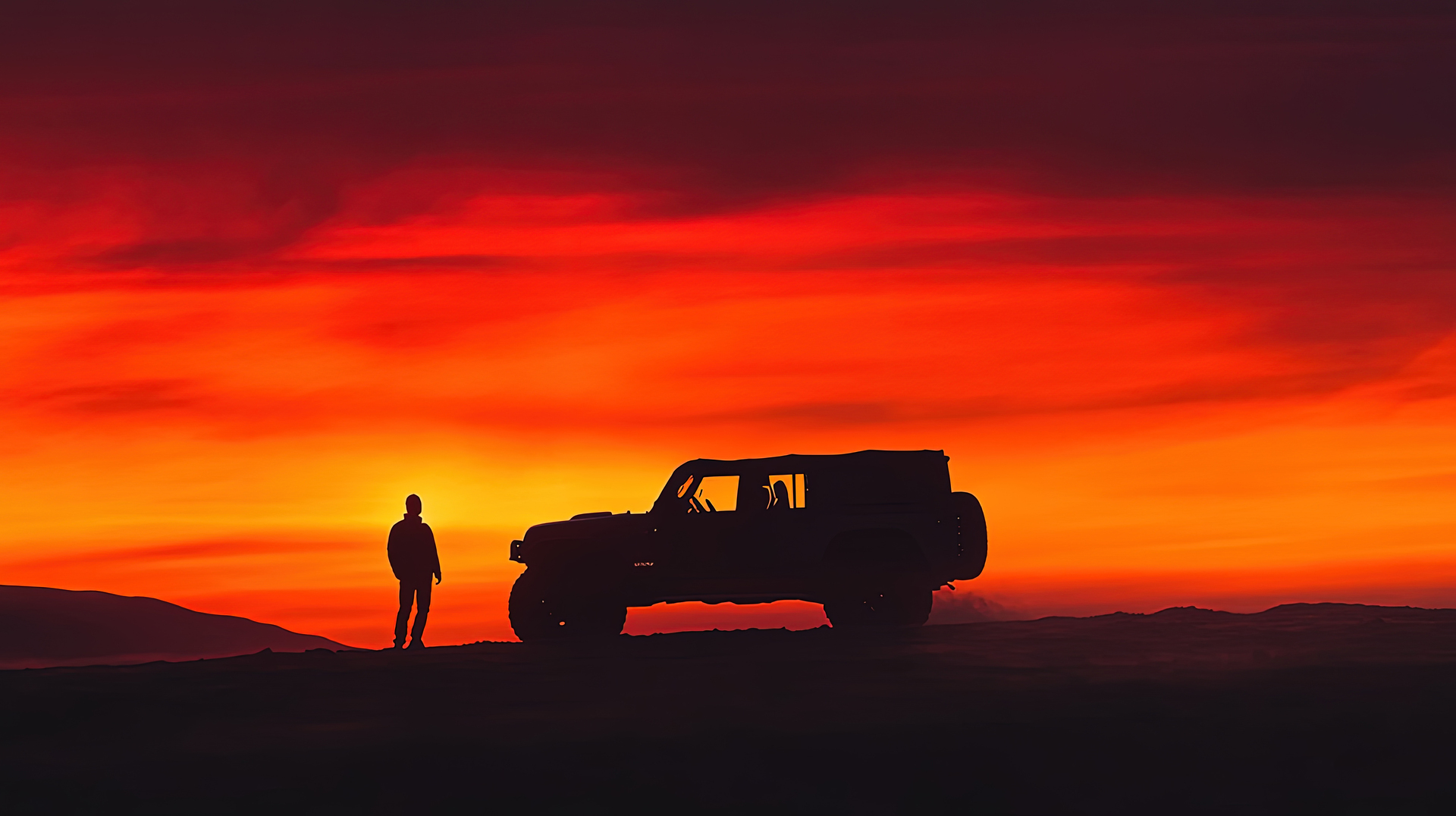 A traveller looking out from an off-road vehicle at sunset
